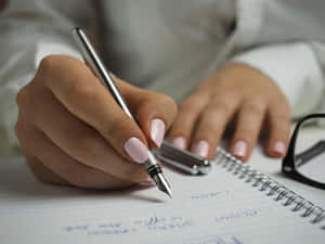 Mão escrevendo com uma caneta-tinteiro em um caderno pautado com óculos por perto. — Writing Aesthetic Papéis de Parede
