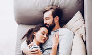 Ett par sover fridfullt tillsammans på en grå soffa. — Soffa Bilder