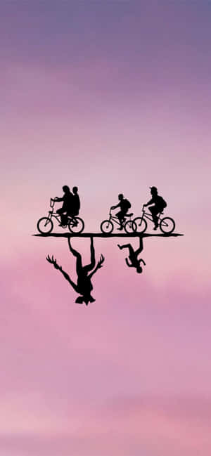 Four cyclists ride on a plank suspended by two upside-down figures against a purple sky. — Cute Aesthetic Picture