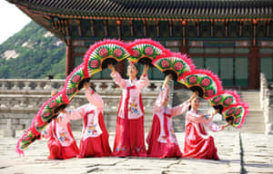 Traditional Korean dancers in hanbok performing with colorful fans at a temple. — Dance Wallpaper