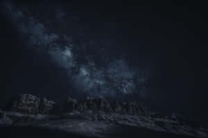 Snowy mountains under a starry night sky with the Milky Way visible. — 4K Dark Mountain Picture