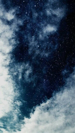 Sterrenhemel met wolken die twinkelende sterren en diepe blauwe kosmische tinten onthullen.