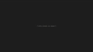 Dunkler Bildschirm mit weißem Programmierkommentar write compile run repeat — Gray Wallpaper