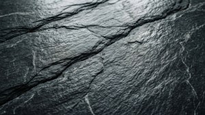 Primo piano di una superficie di ardesia scura che evidenzia le linee di scissione naturali.