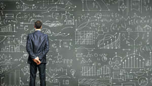 Man in suit facing chalkboard covered in math formulas and financial charts. — Data Wallpaper