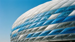 Lyst dagslysbilde av Allianz Arenas ikoniske eksteriør med blå og hvite paneler