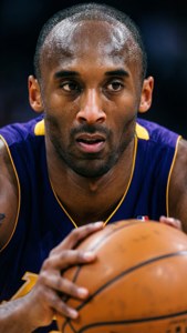 Kobe Bryant in een verdedigingshouding, gefocust en intens.