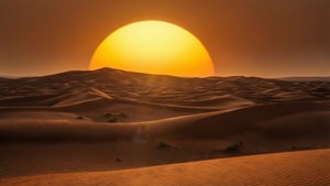 Un medio sol sobre dunas del desierto con tonos cálidos de la hora dorada.
