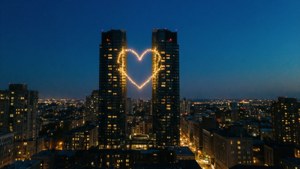 Two lit windows forming a heart in a cityscape wallpaper
