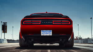 Red Dodge Challenger SRT on drag strip with Michigan license plate under blue sky. — 1991 Dodge Stealth Wallpaper