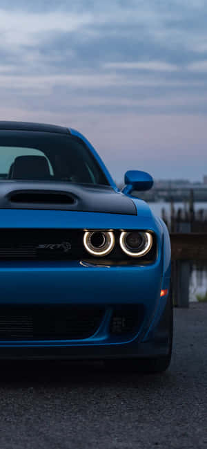 Blauer Dodge Challenger SRT Hellcat mit glühenden Scheinwerfern in der Dämmerung. — Badass Charger Hellcat Wallpaper