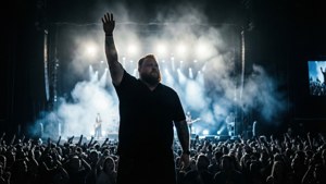 Silhouette di Luke Combs che si esibisce sul palco con un'illuminazione drammatica.