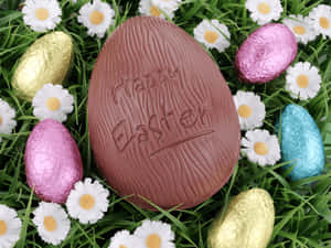 Chocolate Easter egg surrounded by foil eggs and daisies in grass. — Chocolate Wallpaper