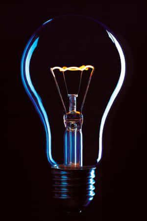A glowing light bulb with blue glass and warm filament light. — Electric Background