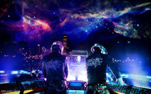 Two DJs in helmets at a concert under a cosmic nebula sky.