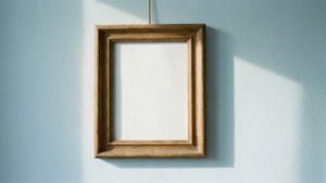 Een eenvoudige houten lijst zonder afbeelding aan een lichtblauwe muur onder zacht schuin licht