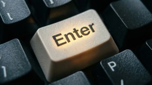 A dramatic macro shot of a glowing 'Enter' key on a dark keyboard. — Keyboard Background