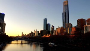 Eureka Tower dan cakrawala Southbank saat matahari terbenam terpantul di Sungai Yarra.