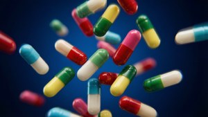 Een dynamisch tafereel van kleurrijke medicijncapsules die neerdalen tegen een donkerblauwe achtergrond.