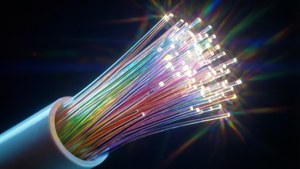 Uno sfondo macro di un cavo in fibra ottica luminoso con colori arcobaleno.