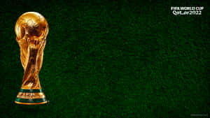 Golden FIFA World Cup trophy on green grass field — Soccer Field Picture