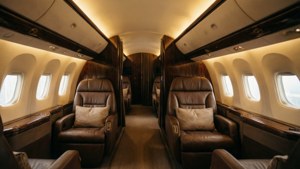 Intérieur de cabine première classe d'American Airlines avec éclairage chaleureux et sièges en cuir.