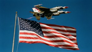 Thunderbirds svever over et stort amerikansk flagg, patriotisk stolthet.