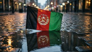 Bandiera dell'Afghanistan riflessa in una pozza piovosa, wallpaper urbano e suggestivo.