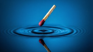 Matchstick floating with reflection in water