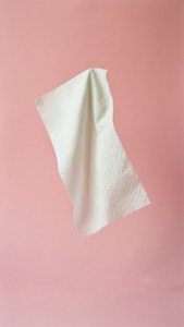 Een zwevend papieren handdoekvel tegen roze, surrealistisch en grillig.