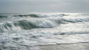 Lunga esposizione di onde bianche schiumose su una spiaggia, sereno e minimalista.