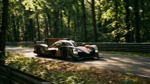 Corrida de carros Le Mans pela floresta com luz solar salpicada.