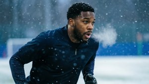 Jahmyr Gibbs playing in a snowy game, cool tones and winter atmosphere.