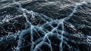 Motifs de glace sur eau d'océan noire.