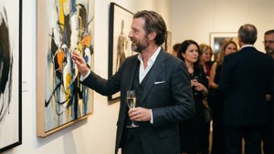 Offset i jakkesæt på et kunstgalleri med champagne
