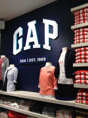 GAP clothing store display with mannequins and stacked apparel on shelves. — T Shirt Picture