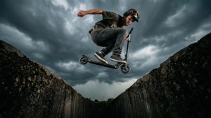 Frontflip skuter freestyle epik melewati celah di bawah langit badai