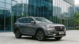 Changan CS75 se reflétant dans un bâtiment moderne en verre.