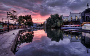 Canal at dusk with colorful sky reflection and moored boats — Google Landscape Background