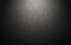 Dark textured surface with a spotlight gradient effect.