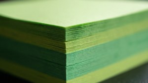 Makrofotografie-Hintergrundbild der geschichteten Kanten grüner Haftnotizen.
