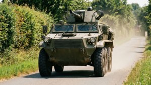 Een Amerikaanse M8 Greyhound pantserwagen op verkenning in het landelijke Frankrijk, die snelheid en mobiliteit vastlegt.