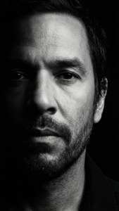 Stark profilporträtt av Zack De La Rocha med dramatisk belysning.