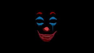 A menacing clown face with dripping makeup on a black background.