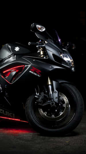 Black Suzuki Hayabusa sport motorcycle with red LED lights in dark setting.