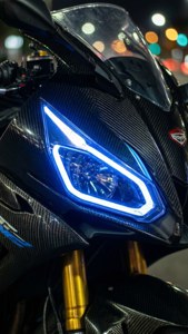 Close-up detail dari lampu depan motor Energica di malam hari