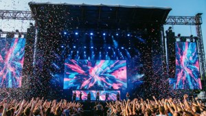 Dynamische opname van het hoofdpodium van Southside Festival met confetti, LED-visuals en springend publiek