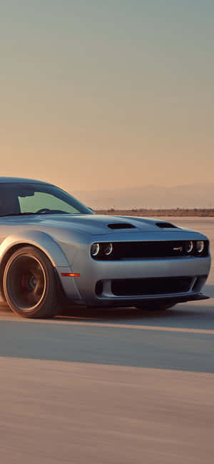 Silberner Dodge Challenger SRT Hellcat rast auf Wüstenstraße bei Sonnenuntergang — Hellstar Wallpaper