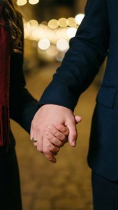 Coppia che si tiene per mano con luci bokeh sfondo