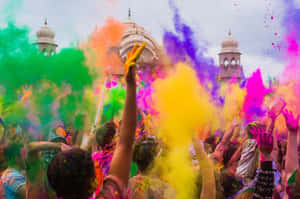 Pessoas jogando alegremente pó colorido durante um festival perto de um templo. — Holi Papéis de Parede